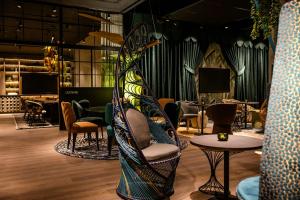 a room filled with chairs and tables and a room with at Motel One München-Hauptbahnhof in Munich
