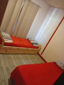 a bedroom with two bunk beds with red sheets at Cabaña in Necochea