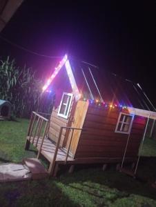 a cabin with lights on the roof at night at Cabaña in Necochea