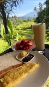 a table with a plate of food and a drink at Abian view house in Sidemen