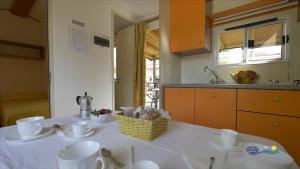 a kitchen with a table with cups and dishes on it at Camping Parisi in Baveno
