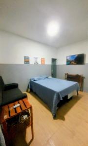 a bedroom with a blue bed and a chair at Ap Umarizal l WiFi 500MB in Belém