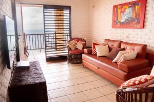 a living room with a couch and a balcony at Casa triplex Lagoinha in Lagoinha