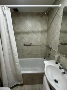 a bathroom with a white tub and a sink at Depto centrico soñado in San Martín de los Andes +21 photos