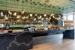 a bar in a restaurant with a counter with food at Motel One Rotterdam in Rotterdam