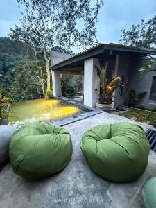 a house with two green bean bags on a patio at Wanora Eco Villa in Dickwella
