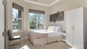 a bedroom with a bed and a desk and windows at Summit Ranch by AvantStay in Temecula +41 photos