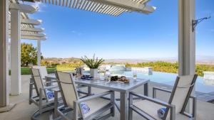 a table and chairs on a patio with a view at Summit Ranch by AvantStay in Temecula