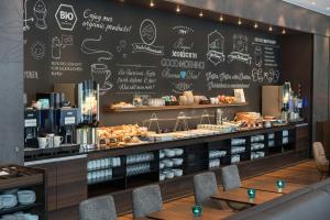 a restaurant with a large chalkboard wall with a bakery at Motel One Leipzig-Nikolaikirche in Leipzig