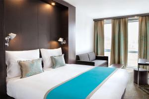 a hotel room with a large bed and a chair at Motel One Manchester-Piccadilly in Manchester