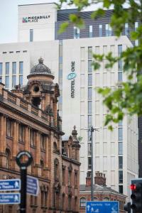 an old building in front of a tall building at Motel One Manchester-Piccadilly in Manchester