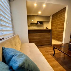 a living room with a couch and a kitchen at Depar 1 Dormitorio F in Cochabamba
