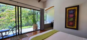 a bedroom with a bed and a view of a bathroom at Olingo Monteverde - Studio Apartment with Jacuzzi in Monteverde Costa Rica
