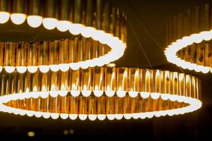 a bunch of gold and white lights hanging from a ceiling at Motel One Essen in Essen