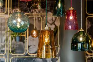 a group of glass lights hanging from a wall at Motel One Essen in Essen