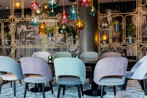 a room with a table and chairs and lights at Motel One Essen in Essen +46 photos