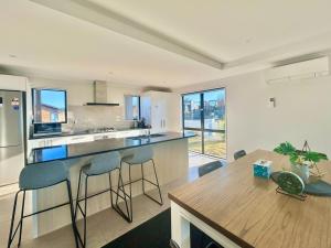 a kitchen with a wooden table and chairs and a dining room at Star River in Lake Tekapo +14 photos