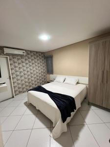 a bedroom with a large white bed in it at Prado Hotel in Salgueiro