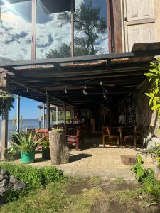 a patio with tables and chairs under a roof at Rancho Morgan in San Lázaro