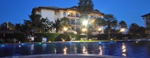 a hotel with a swimming pool at night at Vg Sun Cumbuco Beach House in Caucaia