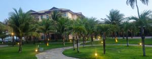 a row of palm trees in front of a building at Vg Sun Cumbuco Beach House in Caucaia