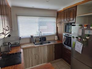a kitchen with a sink and a refrigerator at BR Rooms in a Shared house in Kingston