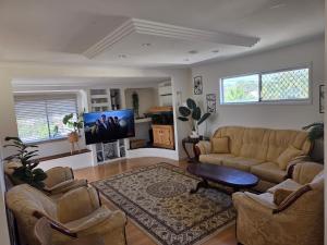 a living room with a couch and a tv at BR Rooms in a Shared house in Kingston
