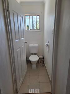 a small bathroom with a toilet and a window at BR Rooms in a Shared house in Kingston +7 photos