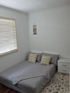 a bed in a room with two pillows on it at BR Rooms in a Shared house in Kingston