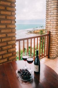 two glasses of wine on a table with a view of the beach at Casa triplex Lagoinha in Lagoinha