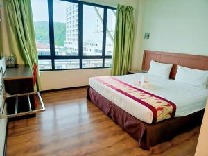 a bedroom with a large bed with a large window at New Palace Inn in Miri