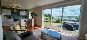 a kitchen and living room with a large sliding glass door at Country Harbourside Escape in Whakapirau