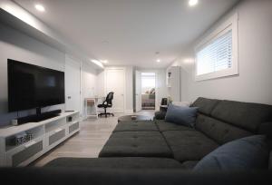 a living room with a couch and a flat screen tv at Warm and Welcoming Basement in Dieppe
