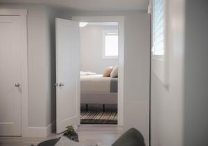 a room with a door open to a bedroom with a bed at Warm and Welcoming Basement in Dieppe