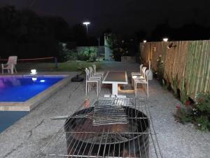 a grill with chairs and a table next to a pool at Kitchaview Poolvilla พูลวิลล่า เชียงราย in Chiang Rai