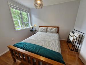 a bedroom with a bed and a window at Country Harbourside Escape in Whakapirau