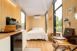a room with a bed and a table with a microwave at Bunjil by Tiny Away in Steels Creek