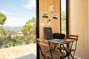 a desk with a laptop on it next to a window at Bunjil by Tiny Away in Steels Creek