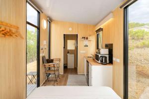a room with a bed and a kitchen with a microwave at Bunjil by Tiny Away in Steels Creek