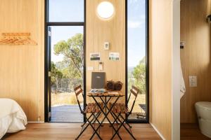 a room with a table with chairs and a bed and a window at Bunjil by Tiny Away in Steels Creek +10 photos