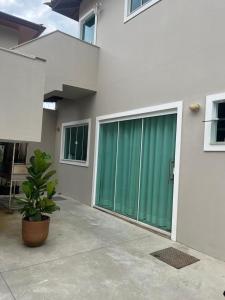 a house with a green door and a potted plant at Apartamento Paraiso Búzios l in Búzios