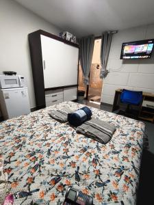 a bedroom with a bed with a comforter on it at Lar Doce Lar Realizando Sono 4 !! in Arcos