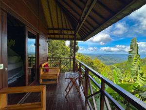 a balcony of a house with a view of the mountains at Munduk V View House in Munduk