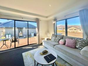 a living room with a couch and a table at Star River in Lake Tekapo