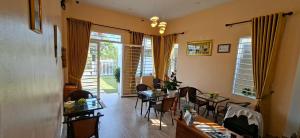 a living room with tables and chairs and a dining room at Rooftop View Home in Kampot