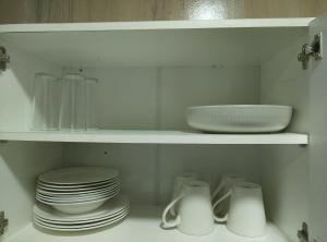 a white shelf with plates and dishes on it at Apartamentos 22 de mayo in Puerto Montt