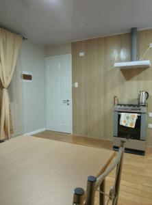 a kitchen with a stove and a door in a room at Apartamentos 22 de mayo in Puerto Montt