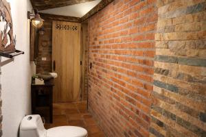 a bathroom with a brick wall and a toilet at Refugio Natural - Guarne - Cabañas Ecológicas con Jacuzzi e hidromasaje in Guarne +85 photos