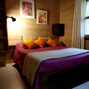 a bedroom with a large bed with orange pillows at Cabaña - El Bamboo Eventos in Arturo SeguÃ­ +62 photos