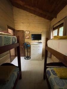 a bedroom with two bunk beds and a television at Cabaña - El Bamboo Eventos in Arturo SeguÃ­